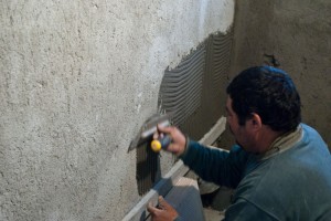 Spreading out adhesive on wall