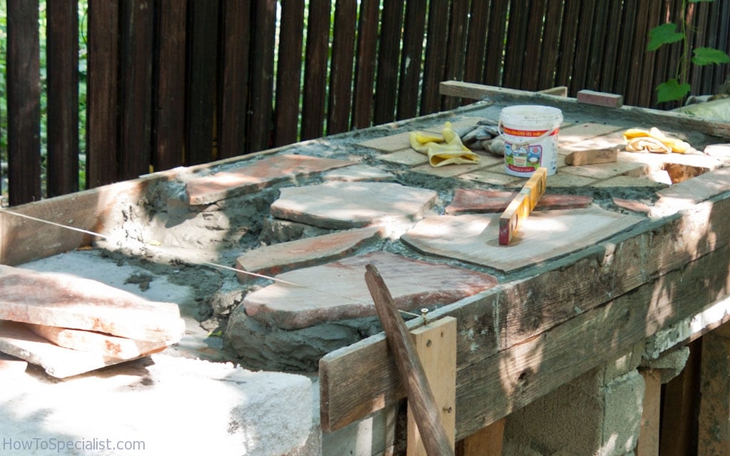 Installing flagstone on the countertop of the outdoor kitchen