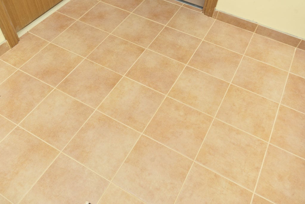 Grouting floor tiles