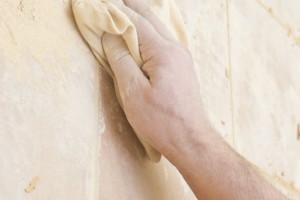 Removing grout off the tiles with a dry cloth Removing grout off the tiles with a dry cloth